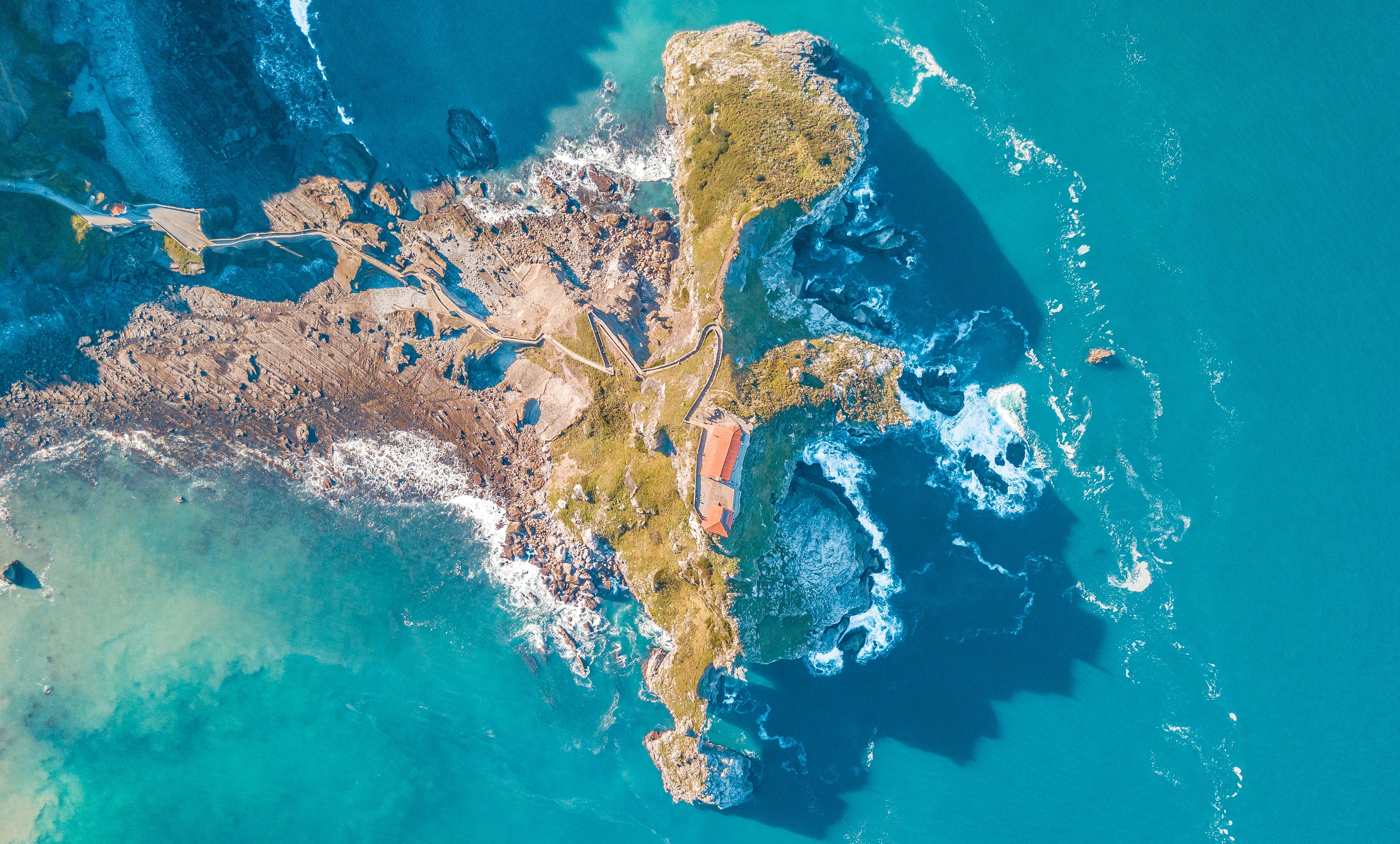 bird's eye view photo of sea waves crushing on boulders